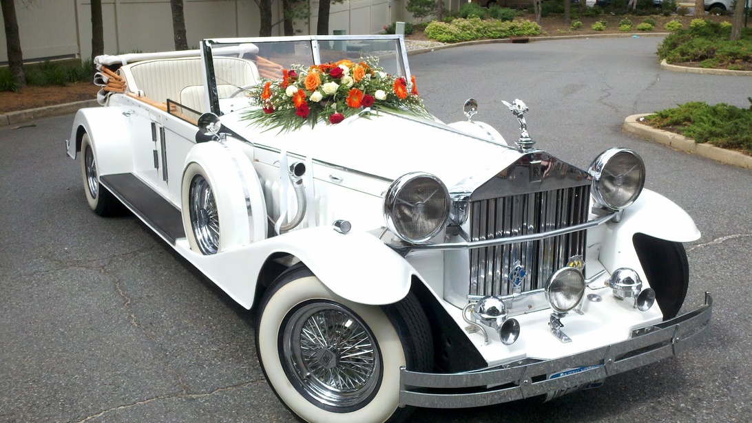 Een witte vintage luxe cabriolet, versierd met bloemen, perfect voor een speciale gelegenheid zoals een feestrit.